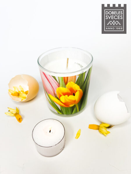 Svece stikla glāzē ar jasmīnu-bumbieru aromātu un košām, pavasarīgām tulpēm uz jostas